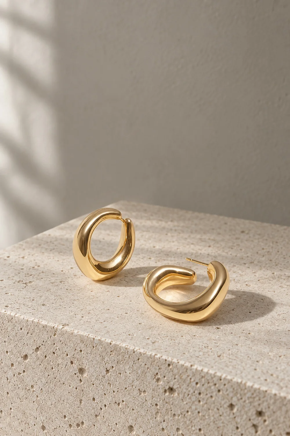 Gold hoop earrings on a limestone block