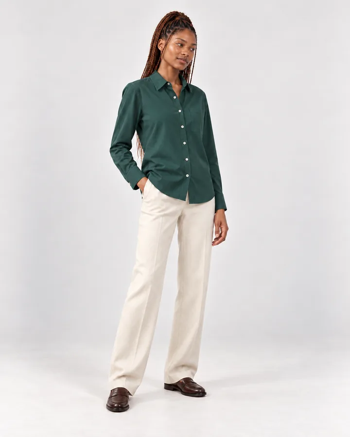 Ready-made model Zola in a green shirt and cream trousers, glancing away with a half-smile